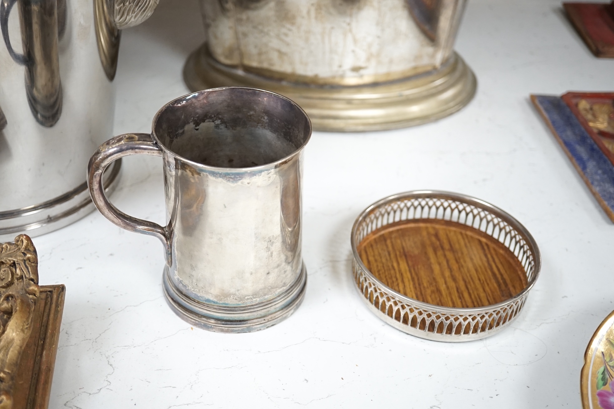 A collection of silver plated and metalware comprising two wine coolers, a tankard and a coaster, largest 29cm high. Condition - fair to good